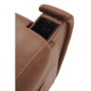 A close-up of the Golden Technologies®️ Titan PR 448, a brown leather armchair featuring a built-in wireless phone charging slot in the armrest, holding a black smartphone.