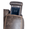 Close-up of the Golden Technologies®️ Titan PR 448 shows a brown leather recliner armrest with visible stitching and an integrated wireless phone charger embedded in the top.