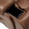 Close-up of the Golden Technologies®️ Titan with Twilight PR 449 brown leather recliner featuring a built-in black rectangular cup holder, holding a black smartphone. The stitching and leather texture are clearly visible.